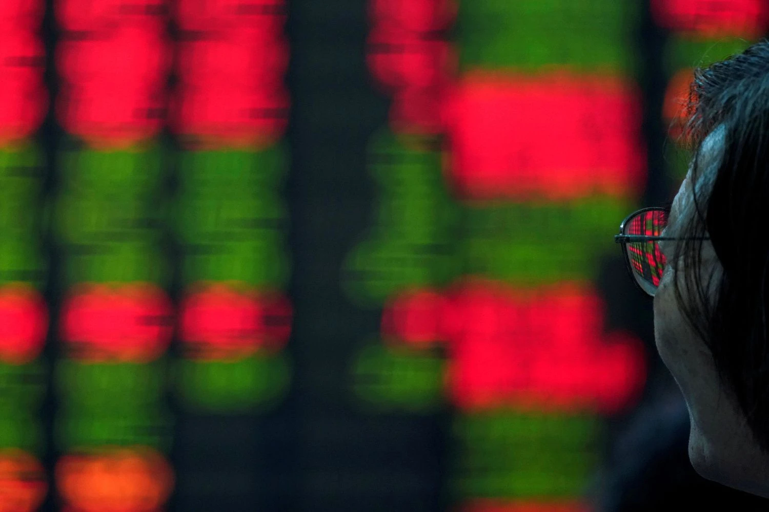 FILE PHOTO An investor looks at an electronic board showing stock information at a brokerage house in Shanghai, China July 6, 2018. REUTERS/Aly Song/File Photo GLOBAL BUSINESS WEEK AHEAD