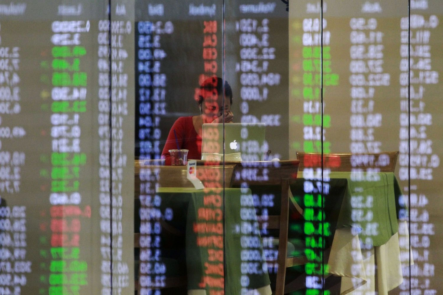 Philippine Stocks Exchange (PSE) share prices are reflected on a glass panel as broker takes a break in Manila's Makati financial district February 6, 2014. Major Southeast Asian stock markets rose on Thursday, with Singapore rebounding from a 14-month closing low hit in the previous session amid gains in Asian stock markets, while bargain hunting helped Thai shares plagued with political risks.  REUTERS/Romeo Ranoco  (PHILIPPINES - Tags: BUSINESS TPX IMAGES OF THE DAY)