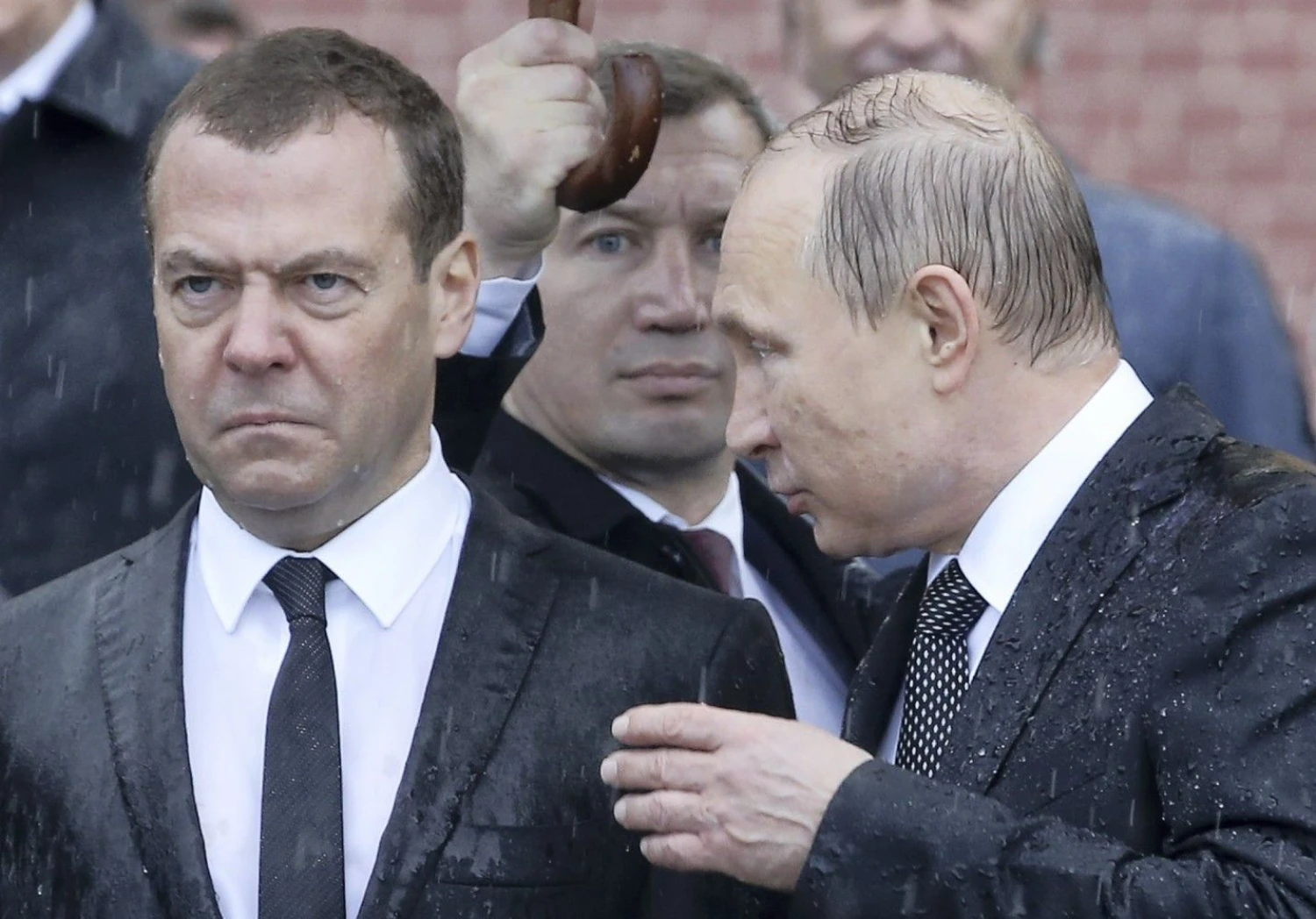 Vis garsiau kalbama, kad Rusijos prezidentas Vladimiras Putinas (dešinėje) ruošiasi atsisveikinti su premjeru Dmitrijumi Medvedevu. Sergejaus Karpuchino („Reuters“) nuotr. 