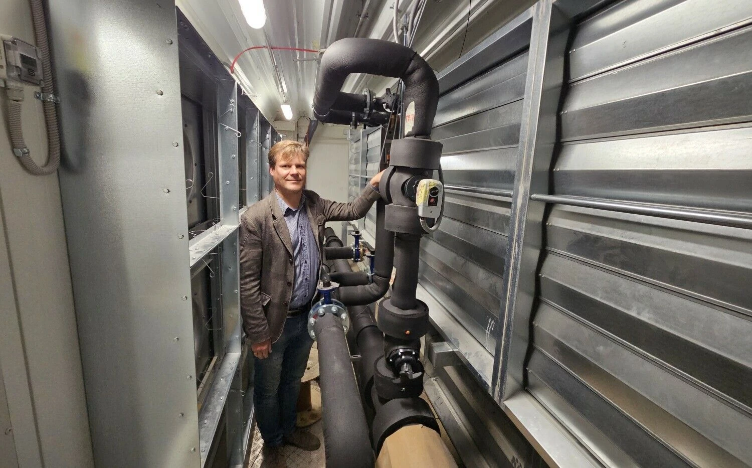 „Tai bus pirmas toks duomenų centro atliekinės šilumos realaus panaudojimo projektas Lietuvoje“, – sako Telecentro Duomenų centrų skyriaus vadovas Giedrius Kalibatas demonstruodamas jau sumontuoto šilumokaičio oras-vanduo mazgą.