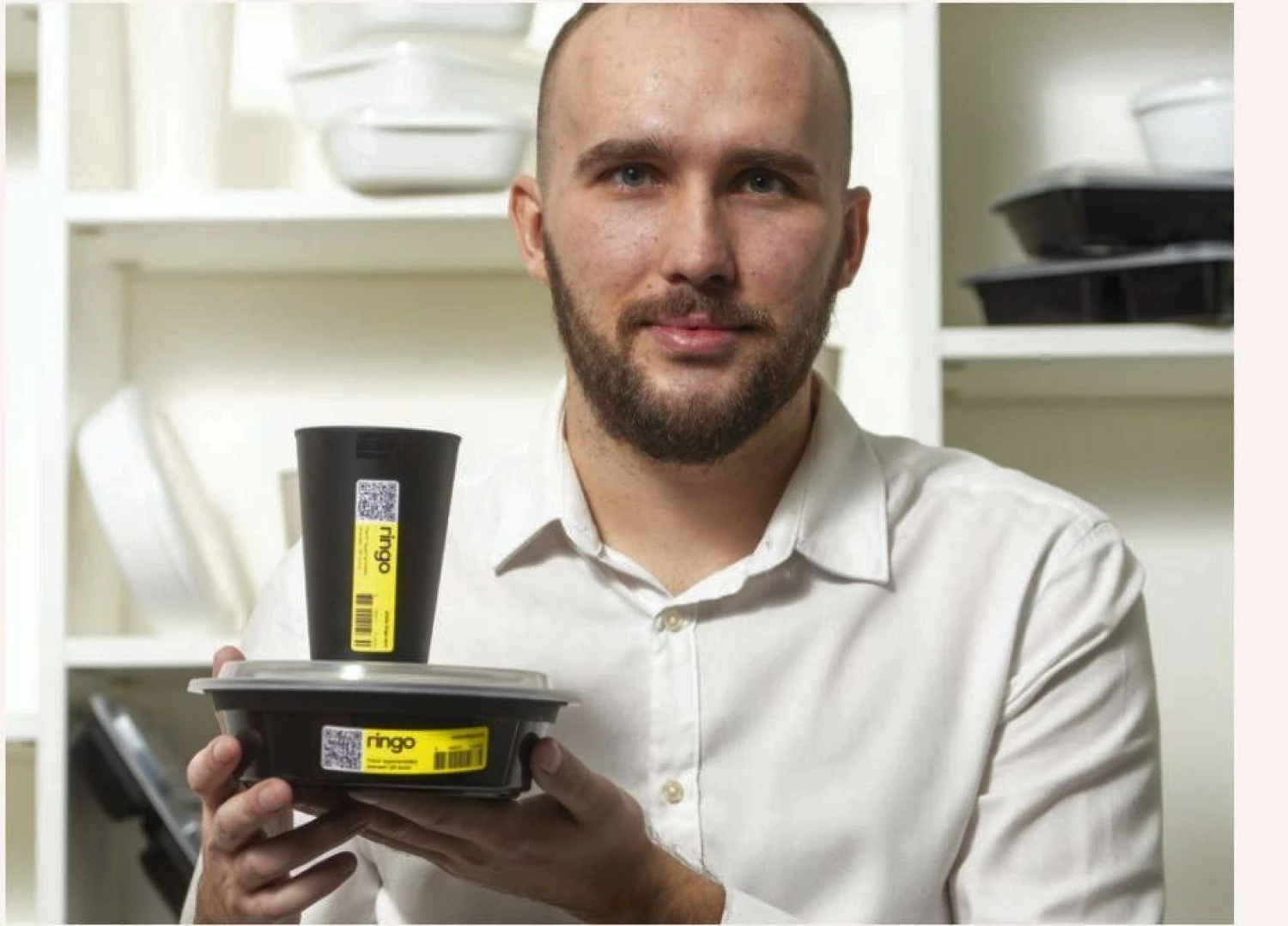 Startuolio „Ringo Eco“ darbuotojas Darius Semper demonstruoja plaunamą pakuotę, skirtą patiekalams. Ekrano nuotr.