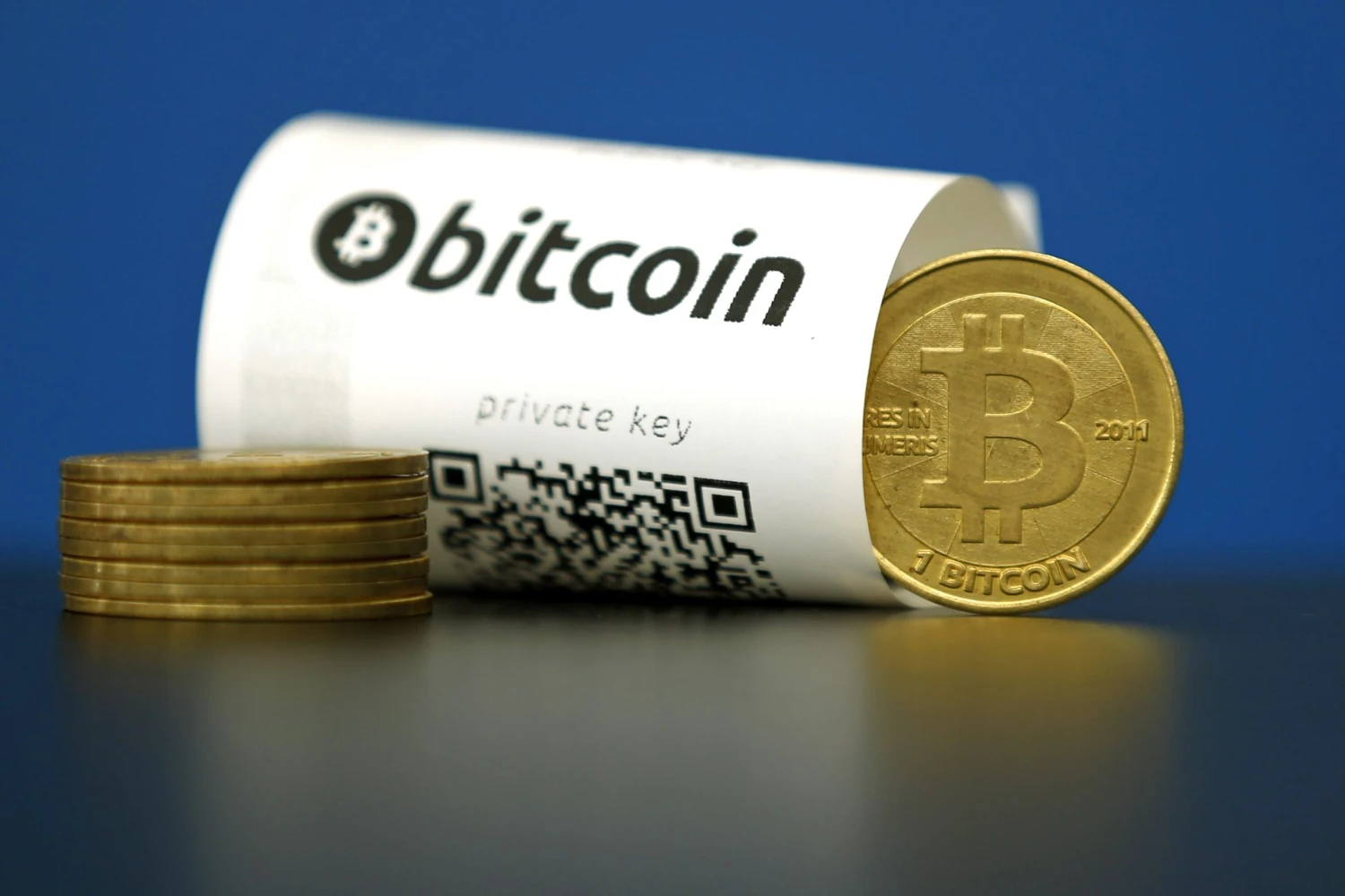A Bitcoin (virtual currency) paper wallet with QR codes and a coin are seen in an illustration picture taken at La Maison du Bitcoin in Paris, France, May 27, 2015. British authorities have come out in support of digital currencies in the name of promoting financial innovation, while proposing that regulations should be drawn up to prevent their use in crime. But it is technophiles who are leading the drive to make London a real-world hub for trade in web-based "cryptocurrencies", of which bitcoin is the original and still most popular.   Picture taken May 27, 2015.  REUTERS/Benoit Tessier