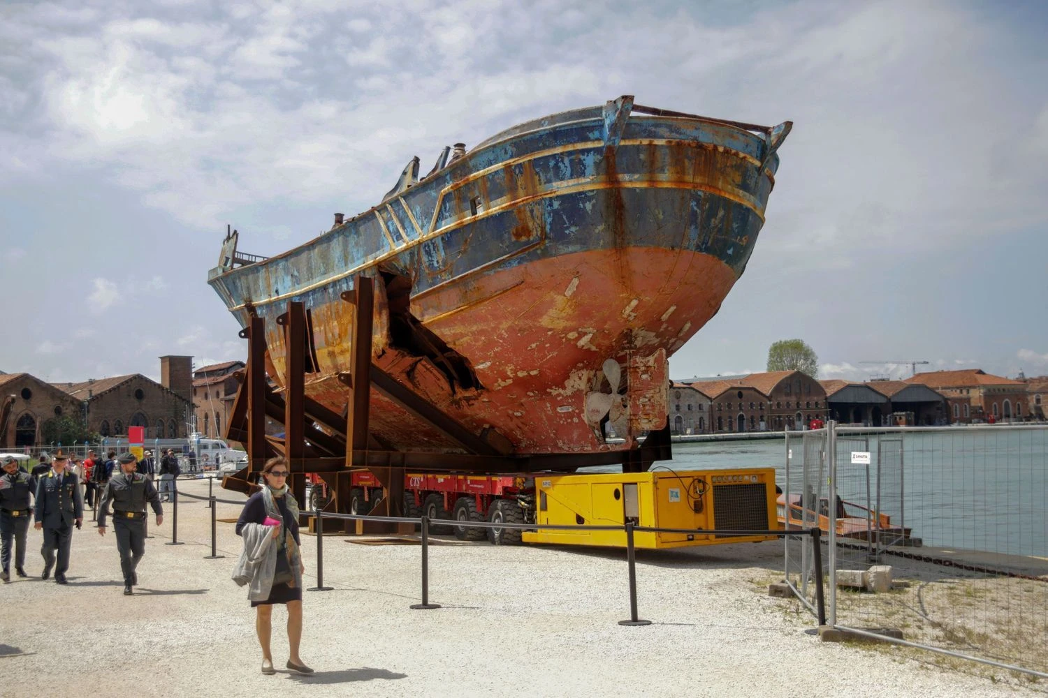 Ar etiška eksponuoti laivą, kuriame žuvo tiek žmonių, net jei tai iš tiesų priartina tragediją, o netoliese stovinčios už šį laivą didesnės privačios jachtos dar išryškina neteisybę? Ant ko pykti? Mirco Toniolo / AGF / SIPA nuotr.