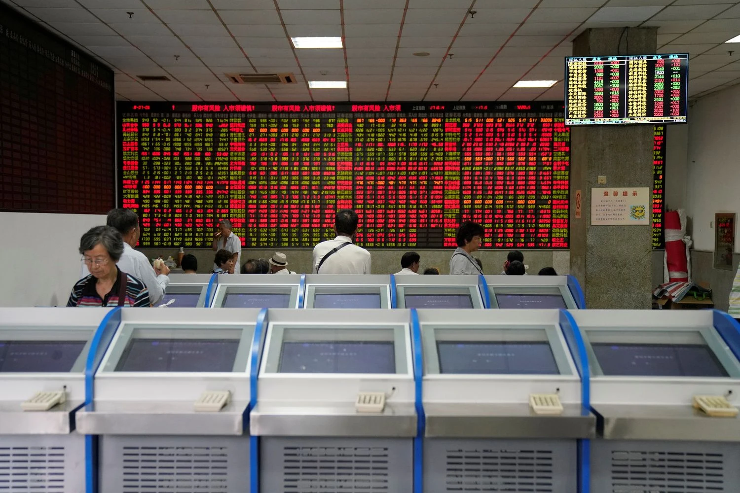 People look at an electronic board showing stock information at a brokerage house in Shanghai, China July 6, 2018. REUTERS/Aly Song