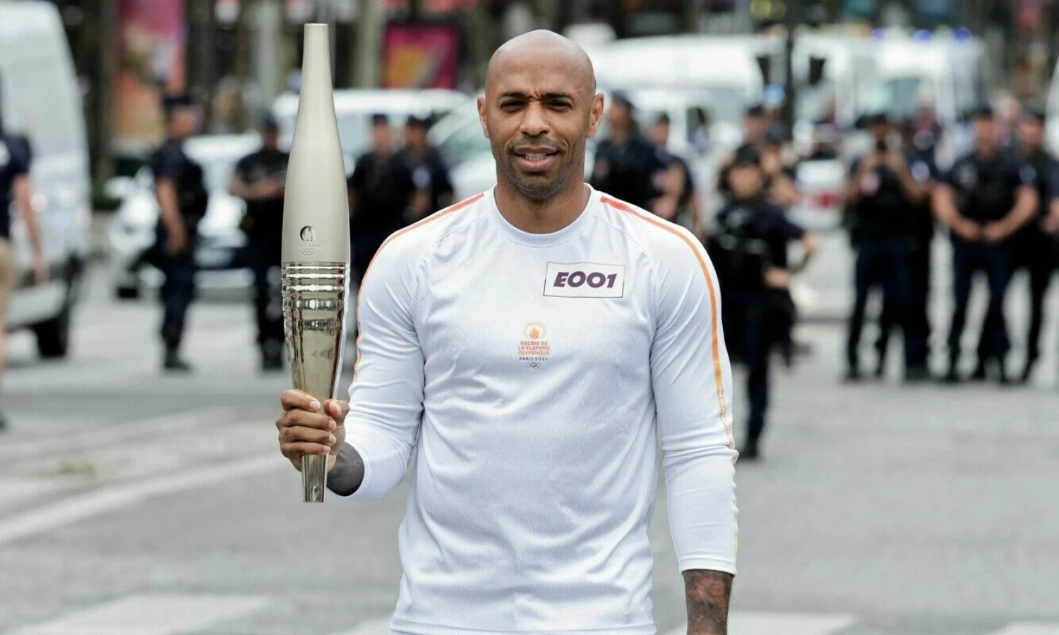 Thierry Henry, 2024 m. olimpinių žaidynių Prancūzijos futbolo rinktinės treneris, laiko olimpinį deglą, kurį pagal užsakymą suprojektavo ir pagamino „Louis Vuitton“, LVMH prekės ženklas, Paryžiaus olimpinių ir parolimpinių žaidynių partneris.