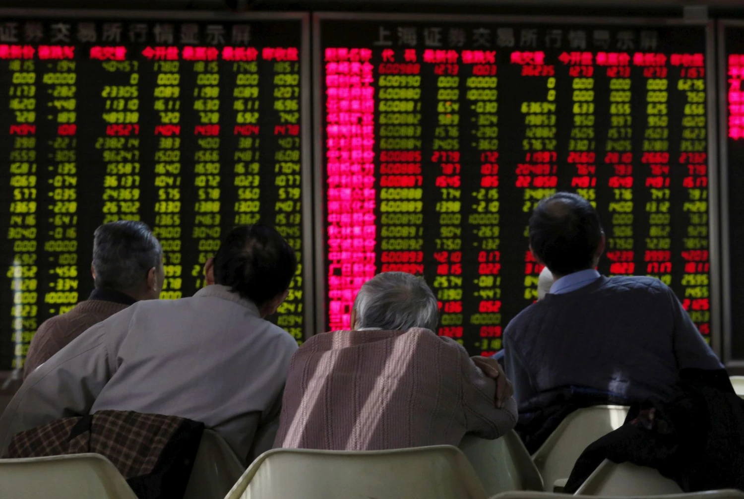 FILE PHOTO: Men look at an electronic board showing stock information at a brokerage house in Beijing, China, January 5, 2016. REUTERS/Kim Kyung-Hoon/File Photo