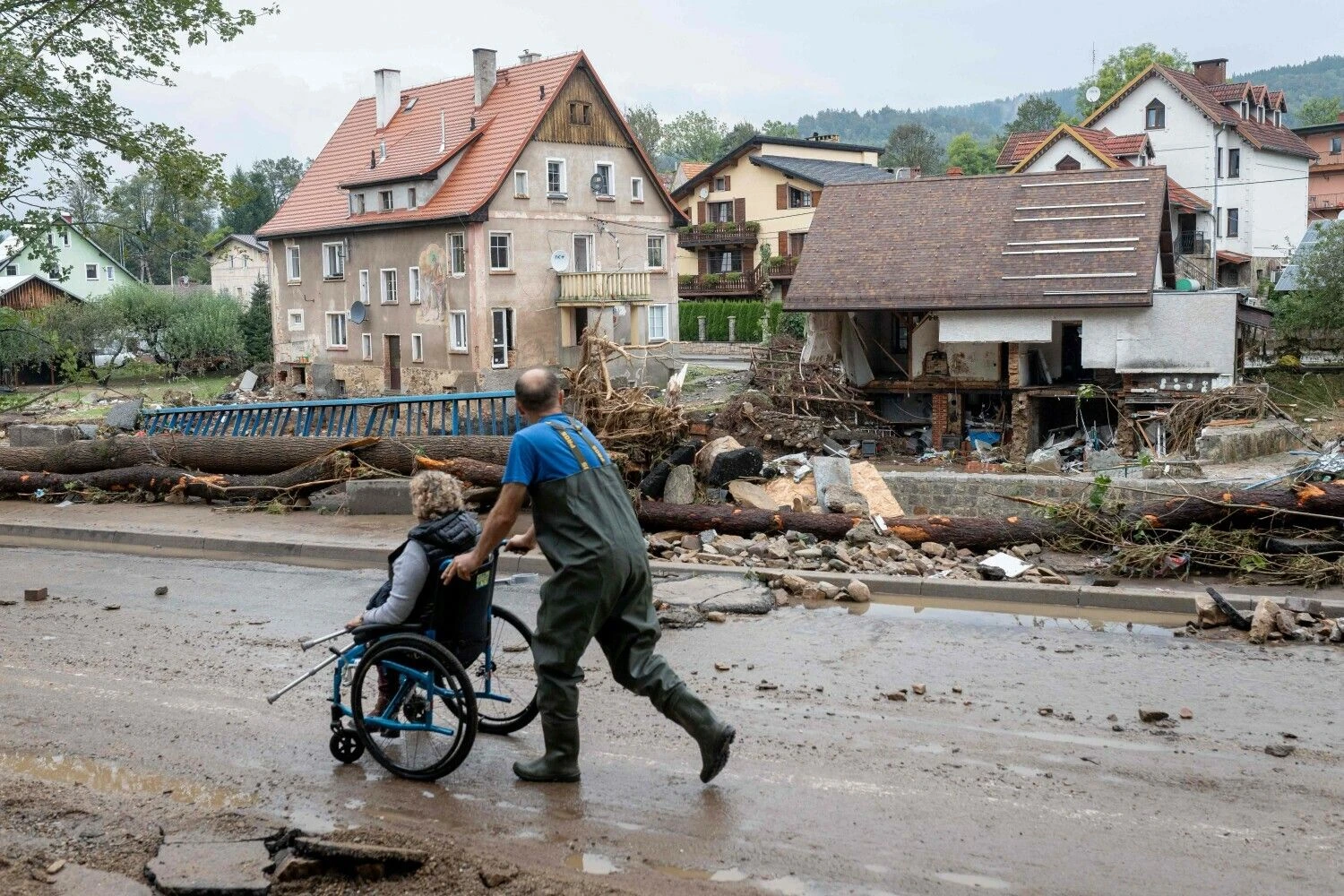 Vyras gelbėja neįgalią gyventoją Ladek-Zdroj mieste, žemutinėje Silezijoje. Mateuszo Slodkowskio (AFP / „Scanpix“) nuotr.