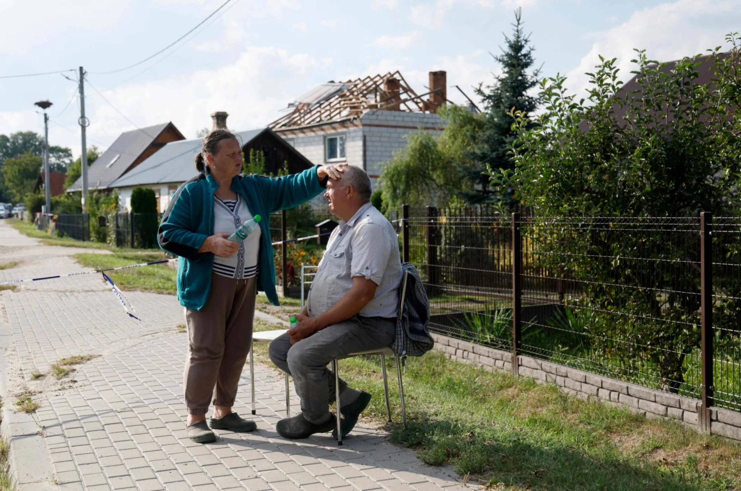 Alicja Wesolowska ir  Tomaszas Wesolowskis prie savo namo, kuris buvo apgriautas naktinės dronų atakos metu. Wojteko Radwanskio (AFP / „Scanpix“) nuotr.