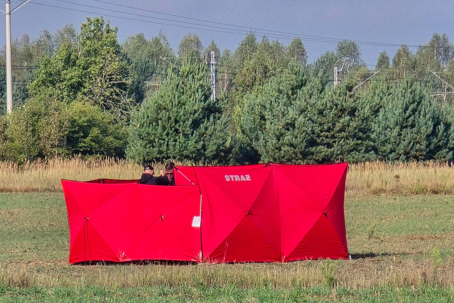 Ugniagesiai saugo numuštų dronų dalis. Piotro Pyrkoszo („AP Photo“ / „Scanpix“) nuotr.