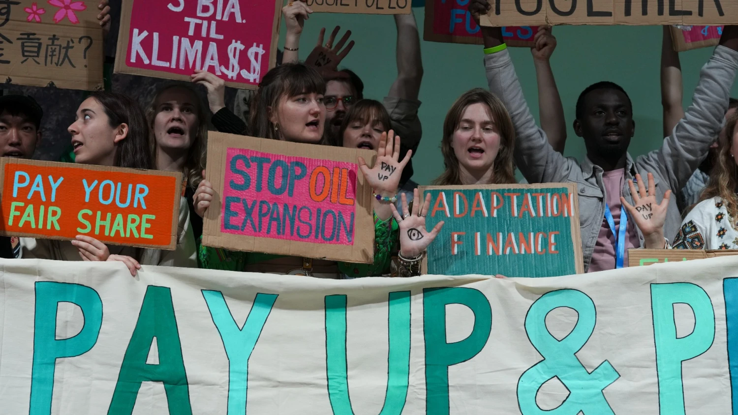 Protestuotojai Azerbaidžane, Baku, vykstančiame COP 29 susitikime ragina didžiąsias ekonomikas mokėti už kuriamą taršą. Peterio Dejongo (AP / „Scanpix“) nuotr.