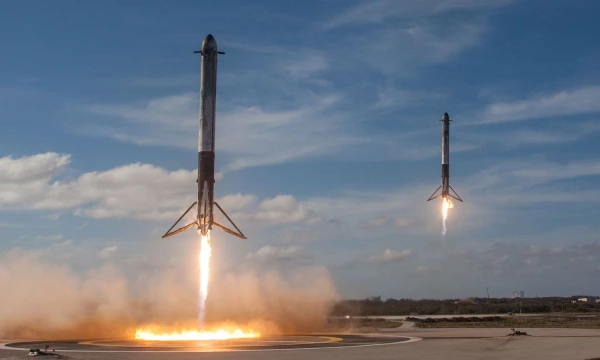 Greičiausiai šitą nuotrauką būtų galima pavadinti 2018-ųjų svarbiausia: Žemėn leidžiasi dvi „Falcon Heavy“ raketos pakopos. „Reuters“ nuotr.