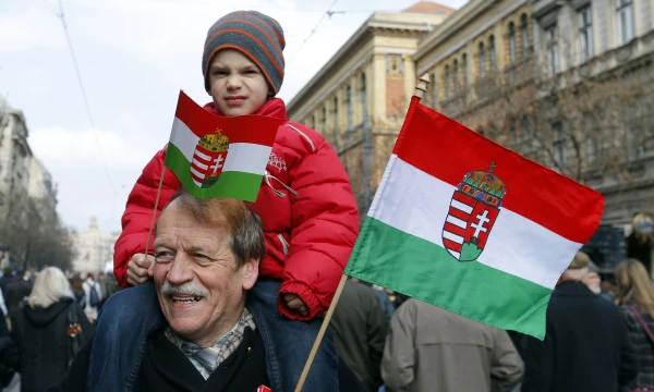 A man and a child hold flags as they attend the Hungary's National Day celebrations, which also commemorates the 1848 Hungarian Revolution against the Habsburg monarchy, in Budapest March 15, 2015. REUTERS/Laszlo Balogh (HUNGARY  - Tags: ANNIVERSARY POLITICS)  