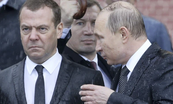 Vis garsiau kalbama, kad Rusijos prezidentas Vladimiras Putinas (dešinėje) ruošiasi atsisveikinti su premjeru Dmitrijumi Medvedevu. Sergejaus Karpuchino („Reuters“) nuotr. 