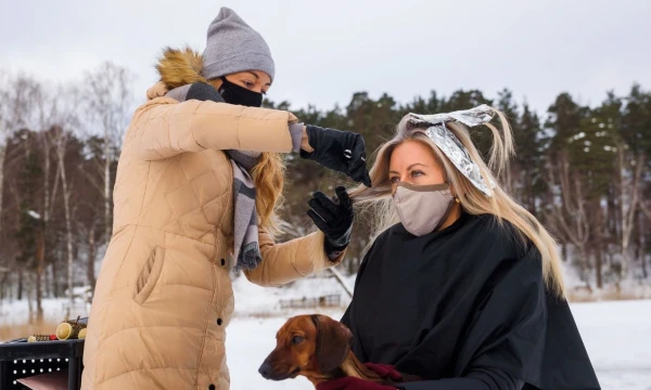 Kirpėja kerpa klientę ant Babelits ežero ledo. Ryga, Latvija.  Gints Ivuskans (AFP / „Scanpix“) nuotr.