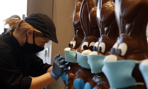 Daugiausia tortus kepanti Atėnų kepylėlė „Lykovrisi“ šokoladinius Velykinius zuikus patobulino veido kaukėmis. Thanassis Stavrakis („Scanpix“) nuotr.