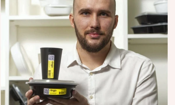 Startuolio „Ringo Eco“ darbuotojas Darius Semper demonstruoja plaunamą pakuotę, skirtą patiekalams. Ekrano nuotr.