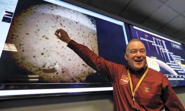 Tomas Hoffmanas rodo nuotrauką, kurią atsiuntė sėkmingai nuisleidęs zondas „Insight“.  (Reuters / Scanpix) nuotr.