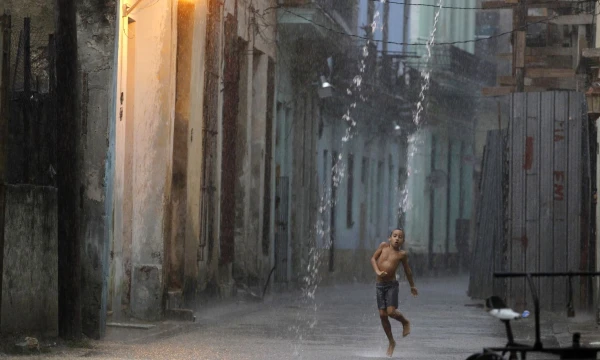 A boy dances in the rain during a heavy tropical shower in a street of Havana July 19, 2010. REUTERS/Desmond Boylan (CUBA - Tags: SOCIETY ENVIRONMENT IMAGES OF THE DAY)