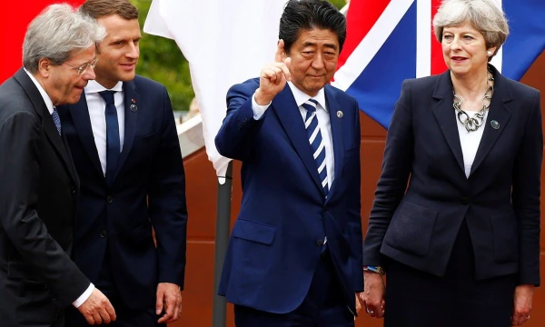 Theresa May, JK premjerė, ir Shinzo Abe, Japonijos ministras pirmininkas, kartu su kitais pasaulio lyderiais G7 susitikime Italijoje. Tony Gentile („Reuters“ / „Scanpix“) nuotr.
