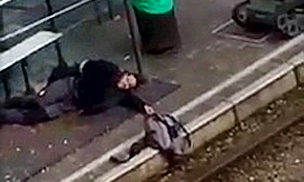 Policijos sužeistas asmuo guli tramvajaus stotelėje, rankoje laikydamas krepšį, kuriame, įtariama, galėjo būti sprogmenys. „Reuters“ / „Scanpix“ nuotr. 