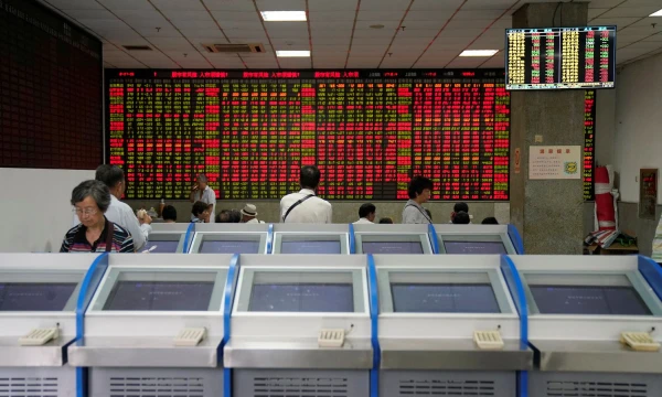 People look at an electronic board showing stock information at a brokerage house in Shanghai, China July 6, 2018. REUTERS/Aly Song