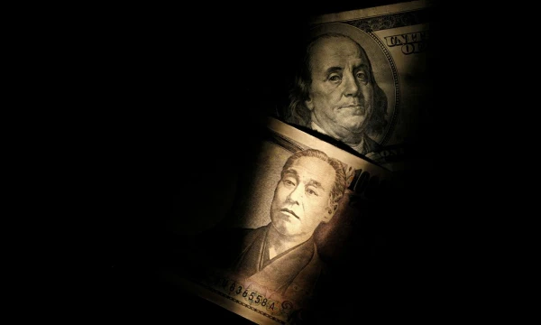 FILE PHOTO: Light is cast on a U.S. one-hundred dollar bill next to a Japanese 10,000 yen note in this picture illustration shot February 28, 2013.   REUTERS/Shohei Miyano/Illustration/File Photo