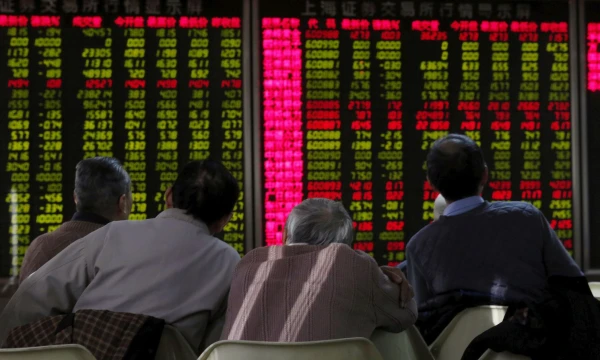 FILE PHOTO: Men look at an electronic board showing stock information at a brokerage house in Beijing, China, January 5, 2016. REUTERS/Kim Kyung-Hoon/File Photo