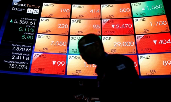 FILE PHOTO - A worker walks next to an electronic stock board at the Indonesia Stock Exchange in Jakarta, Indonesia February 3, 2017. REUTERS/Beawiharta/File Photo