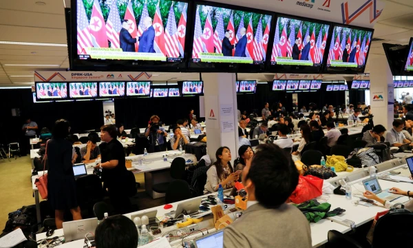 A TV screen shows a news report about the meeting between U.S. President Donald Trump and North Korea's leader Kim Jong Un at a media center for the summit, in Singapore June 12, 2018. REUTERS/Tyrone Siu     TPX IMAGES OF THE DAY