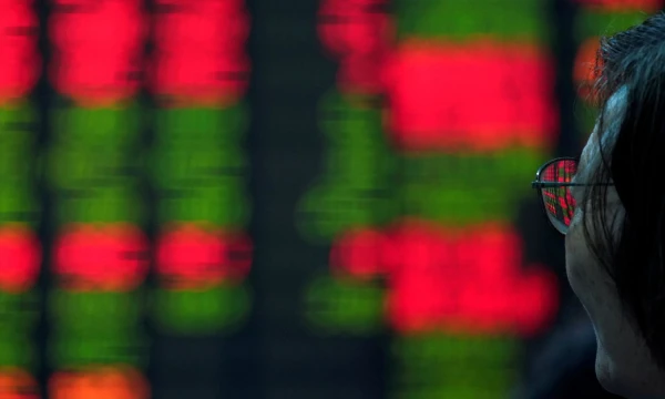 FILE PHOTO: An investor looks at an electronic board showing stock information at a brokerage house in Shanghai, China July 6, 2018. REUTERS/Aly Song/File Photo