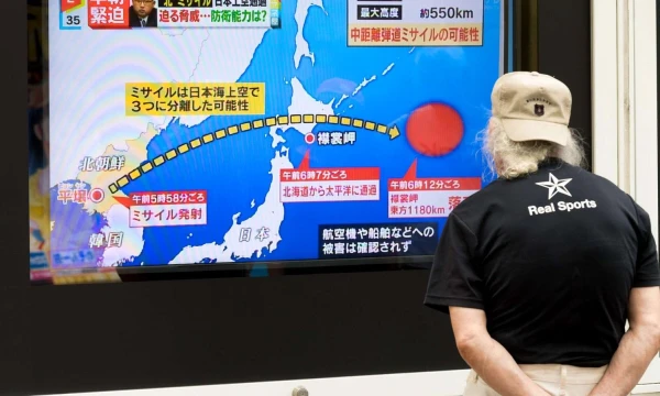 Praeivis Japonijoje stebi Šiaurės Korėjos paleistos raketos trajektoriją, kuri kirto Japonijos teritoriją. „Sipa“ / „Scanpix“ nuotr.